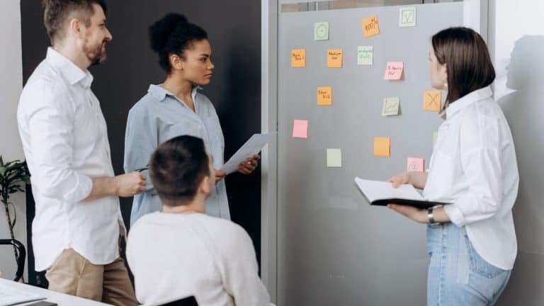 Law firm team reviewing workflow sticky notes on a wall to tackle the challenges facing law firms in 2026